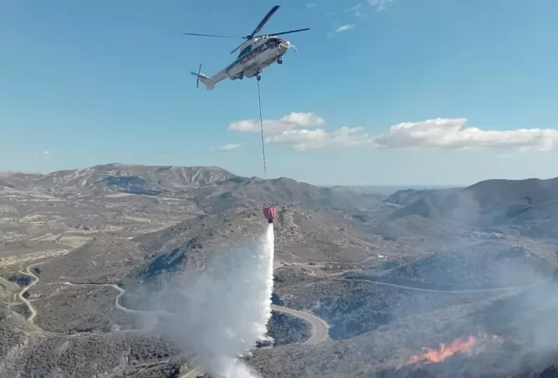 Un helicptero Sper Puma descargando agua sobre un incendio forestal. Foto: INFOCA