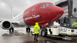 Aeronave de Norwegian en pista acoplada a equipos de handling de Aviator. Foto: Norwegian