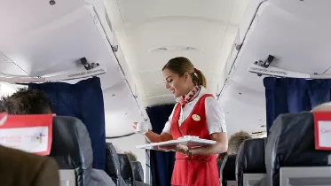 Tripulante de cabina de pasajeros atendiendo a un cliente en un avi�n de Air Nostrum. Foto: Air Nostrum