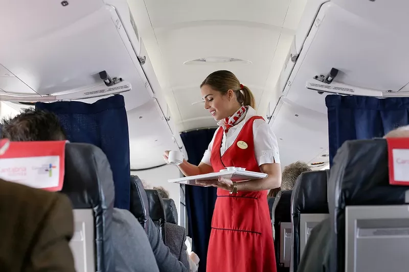 Tripulante de cabina de pasajeros atendiendo a un cliente en un avi�n de Air Nostrum. Foto: Air Nostrum