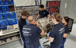 Alumnos junto a un instructor trabajando sobre un motor. Foto: Aviation Group