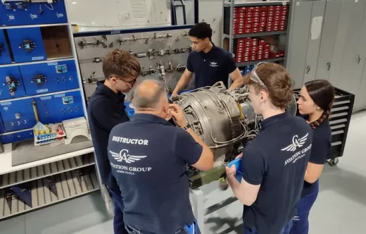 Alumnos junto a un instructor trabajando sobre un motor. Foto: Aviation Group