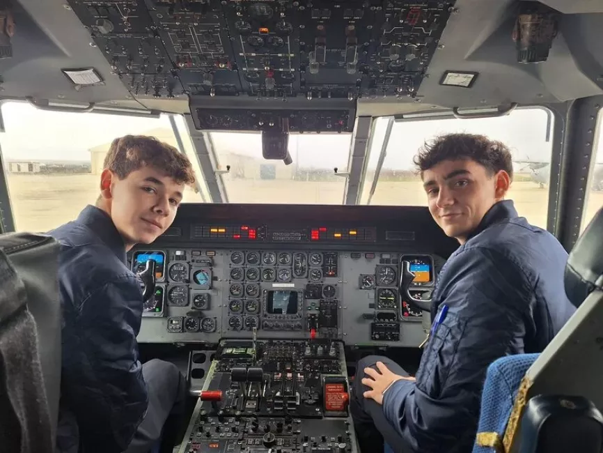 Cadetes posan en el puesto de operación de un avión CASA. Foto: Adeventia